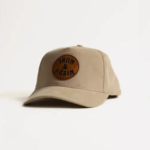 Beige cap with a brown leather patch on a white background