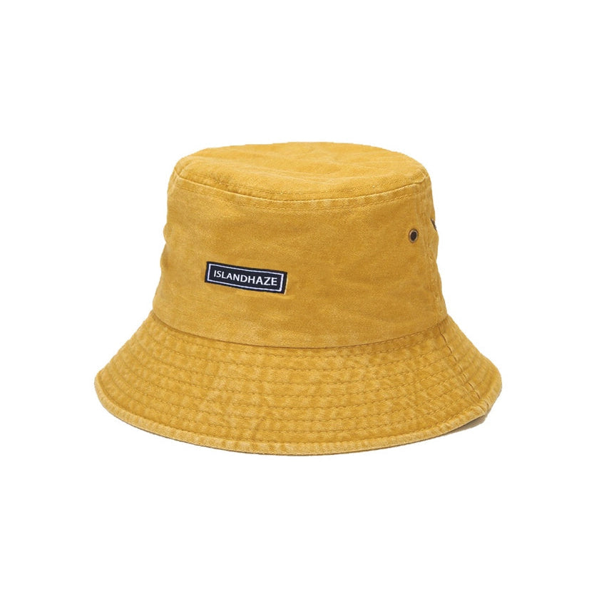 Yellow bucket hat with a brand label on a white background