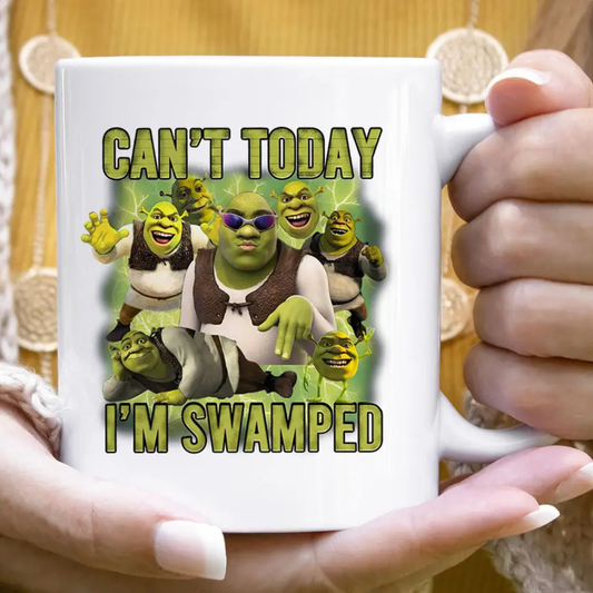 Mug with Shrek design and text 'Can't today, I'm swamped' held by a person.